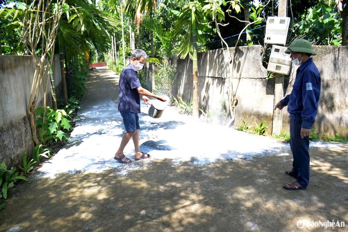 Cán bộ thú y xã Thanh Phong hướng dẫn người dân thực hiện các giải pháp phòng, chống dịch tả lợn châu Phi, trong đó có rắc vôi bột trước ngõ. Ảnh: Xuân Hoàng