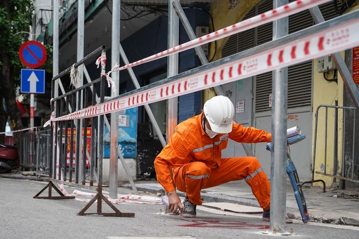  Công nhân điện lực dùng máy chuyên dụng để xác định dây cáp điện ngầm dưới lòng đất, đảm bảo khu vực thi công được khoanh vùng an toàn, sẵn sàng cho các quy trình tiếp theo của việc tháo dỡ. 