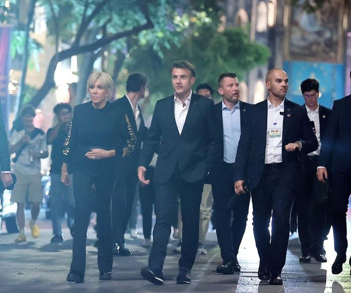 Tổng thống Pháp Emmanuel Macron và Phu nhân nắm tay nhau cùng dạo phố cổ Hà Nội. Ảnh: TTXVN