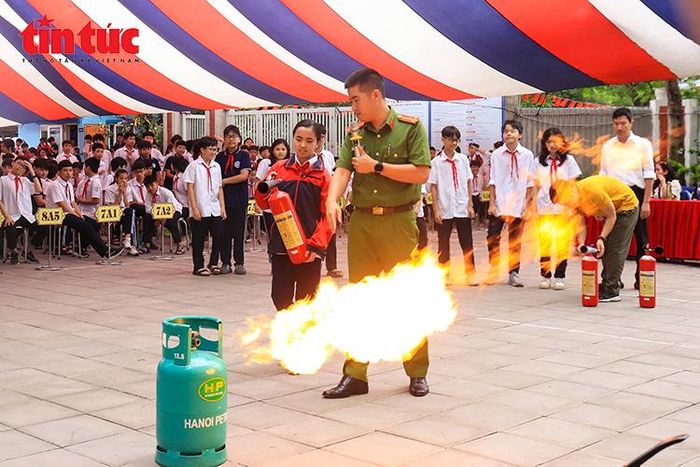 Cán bộ, giáo viên và học sinh thực hành sử dụng bình chữa cháy dập tắt đám cháy rò rỉ khí gas.