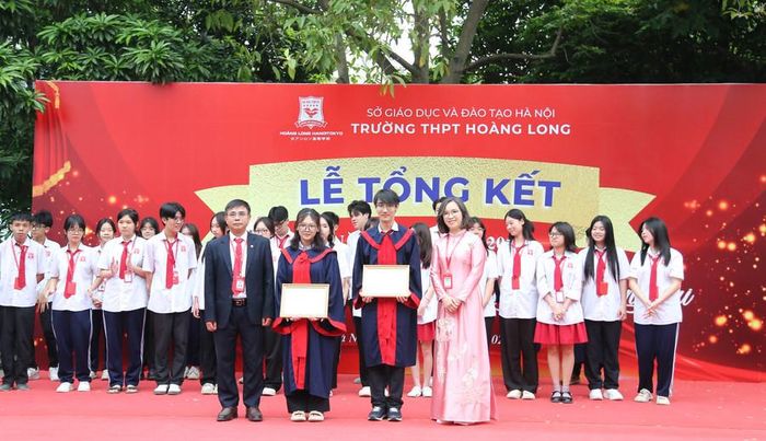  TS. Hoàng Việt và cô Đào Thị Thu Trang - Phó Hiệu trưởng nhà trường trao khen thưởng cho các em học sinh trong buổi lễ tổng kết. 