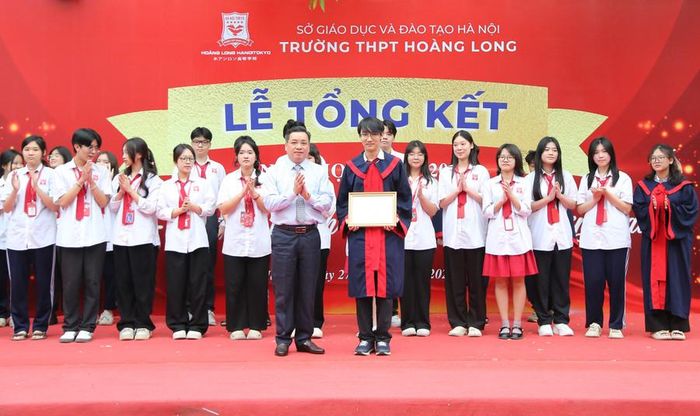  Ông Lê Thanh Long - Chủ tịch Hội đồng Trường THPT Hoàng Long trao khen thưởng cho các em học sinh. 