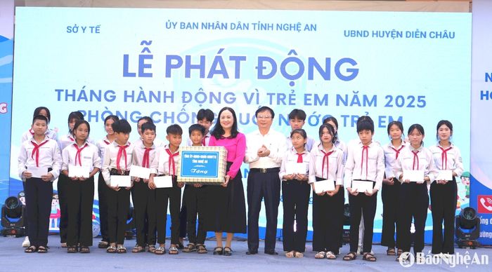 Đồng chí Bùi Đình Long - Phó Chủ tịch UBND tỉnh và đồng chí Trần Thị Thu Hương - Phó Chủ tịch Ủy ban MTTQ tỉnh trao quà của Tỉnh ủy - HĐND - UBND - Ủy ban MTTQ tỉnh cho học sinh khó khăn trên địa bàn huyện Diễn Châu. Ảnh: Mỹ Hà