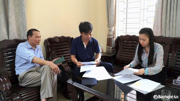 Chủ tịch UBND xã Nghi Thiết, ông Bùi Văn Thành (ngồi ngoài, bên trái) trao đổi việc giải quyết khiếu nại với PV Báo Nghệ An. Ảnh: Võ Hải