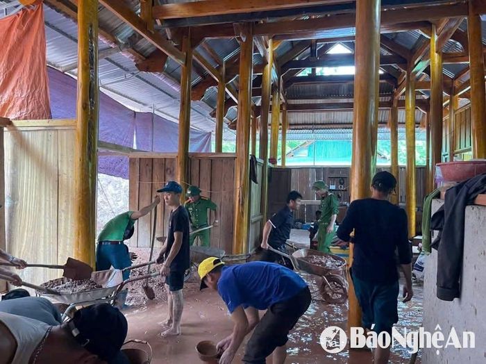 Các lực lượng giúp người dân bản Piêng Vai khắc phục nhà cửa hư hỏng sau mưa lũ. Ảnh: PV