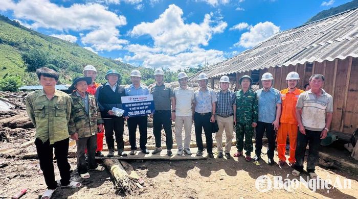 Đoàn công tác trao tiền hỗ trợ tại xã Nhôn Mai. Ảnh: Linh Chi