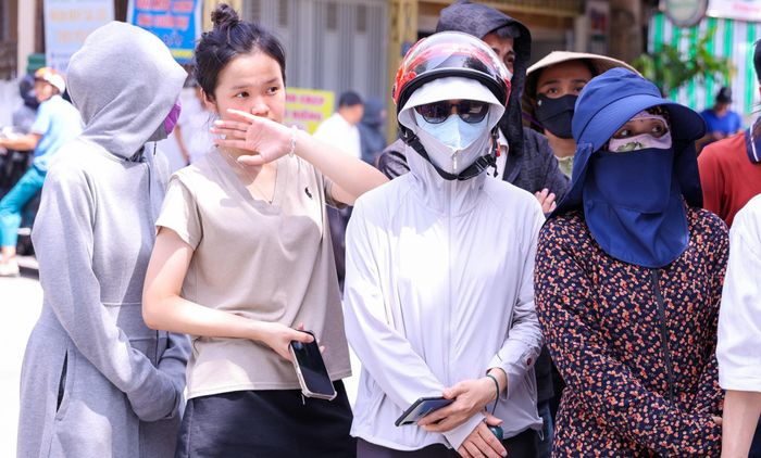 Dù thời tiết khắc nghiệt, phụ huynh vẫn kiên trì chờ đợi ngoài cổng trường suốt buổi thi. Bởi họ hiểu, chỉ cần mình ở đó là con có điểm tựa tinh thần vững vàng để bước tiếp. Ảnh: Đức Anh