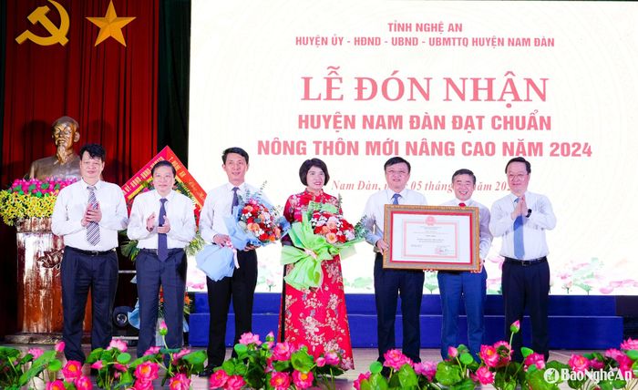 Thừa ủy quyền, đồng chí Nguyễn Đức Trung - Bí thư Tỉnh ủy trao Bằng công nhận huyện đạt chuẩn nông thôn mới nâng cao cho lãnh đạo huyện Nam Đàn; đồng chí Lê Hồng Vinh - Phó Bí thư Tỉnh ủy, Chủ tịch UBND tỉnh và đồng chí Trần Nhật Lam - Phó Chánh Văn phòng Điều phối nông thôn mới Trung ương tặng hoa chúc mừng. Ảnh: Phạm Bằng