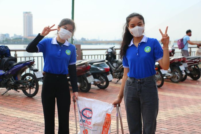 Thành viên Hội Yêu rác Đà Nẵng dọn rác hai bên bờ sông Hàn sau đêm diễn ra lễ hội bắn pháo hoa quốc tế.