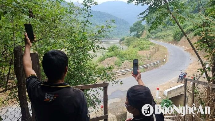 Tác nghiệp ở vùng cao, nơi sóng điện thoại chập chờn, phải "hứng sóng". Ảnh: Hoài Thu