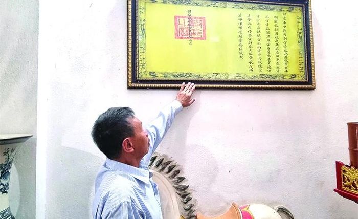 Ông Lê Công Thắng, người đang trực tiếp trông coi đền thờ giới thiệu về sắc phong và sắc chỉ các triều vua ban cho tướng quân Lê Công Trực.