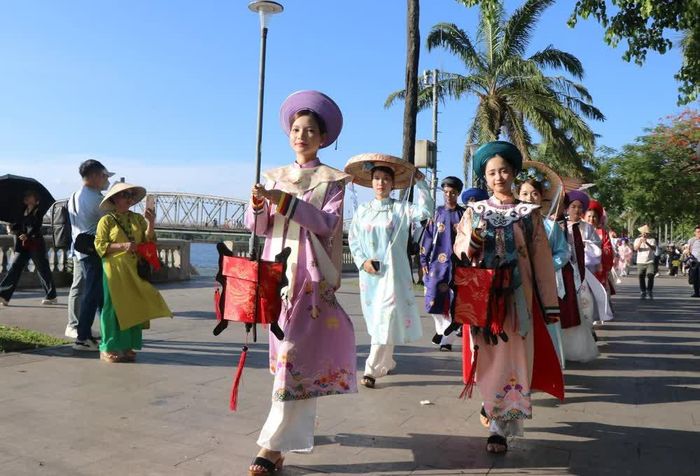 Khởi hành từ Nghinh Lương Đình, men theo đường đi bộ dọc bờ sông Hương thơ mộng, đoàn diễn hành dừng lại quảng trường phía trước Trường Quốc Học Huế. Ảnh: Tường Vi/TTXVN