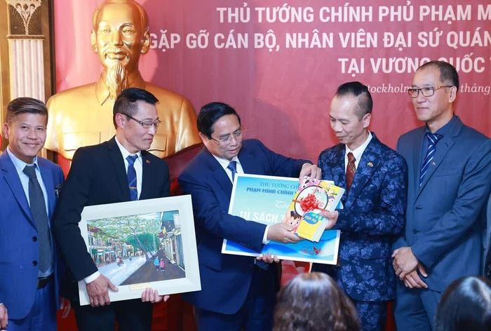 Thủ tướng Phạm Minh Chính tặng quà cho đại diện cộng đồng người Việt Nam tại Thụy Điển. Ảnh: Dương Giang-TTXVN