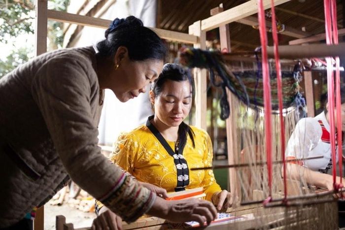 Nghệ nhân Sầm Thị Bích truyền dạy kỹ thuật dệt màn cho các chị em trong bản Hoa Tiến, xã Châu Tiến, huyện Quỳ Châu, tỉnh Nghệ An. Ảnh: Hoa Tiến Brocad