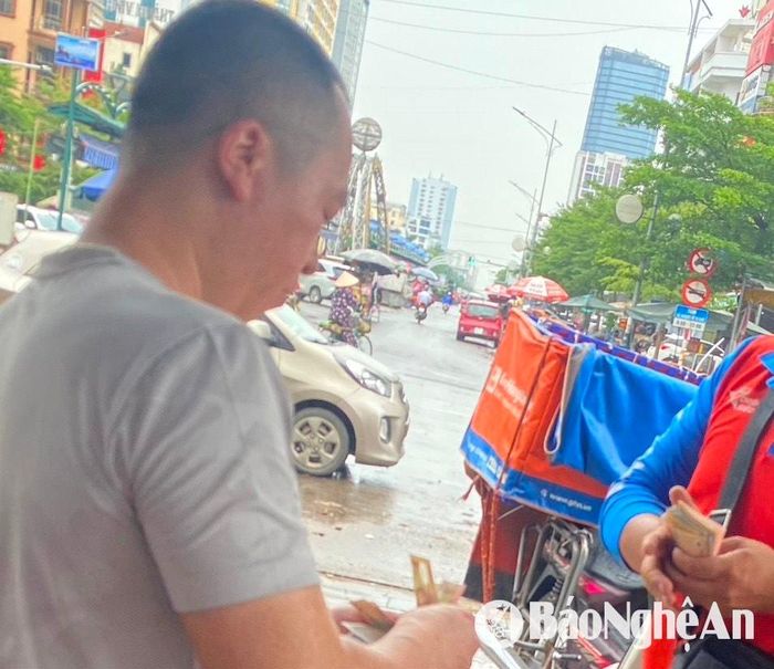 Các shipper giao hàng online ở thành phố Vinh cũng nhận tiền mặt. Ảnh: Hải An