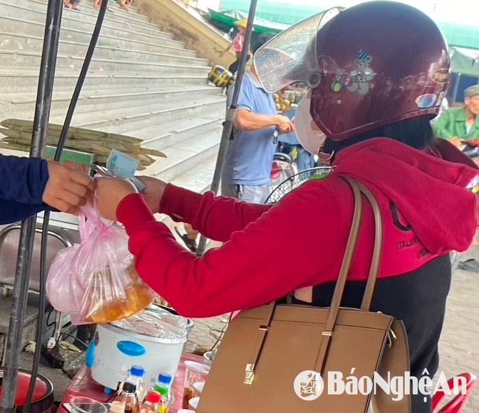 Một chủ quán chè tại chợ Vinh nhận giao dịch tiền mặt từ khách hàng. Ảnh: Hải An