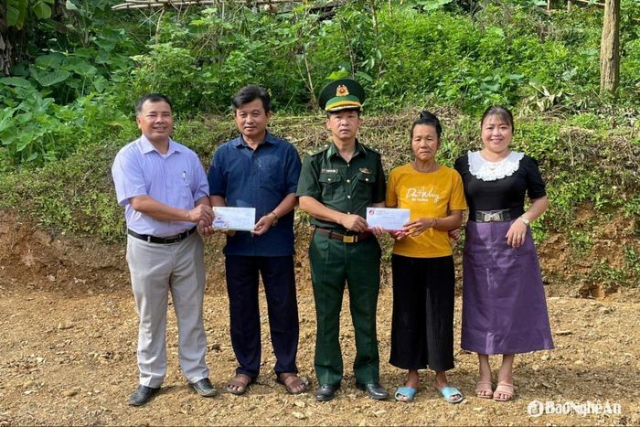 Đại diện Đồn Biên phòng Nhôn Mai và UBND xã Nhôn Mai trao tiền hỗ trợ của các nhà hảo tâm đến tận tay các hộ gia đình. Ảnh: HT