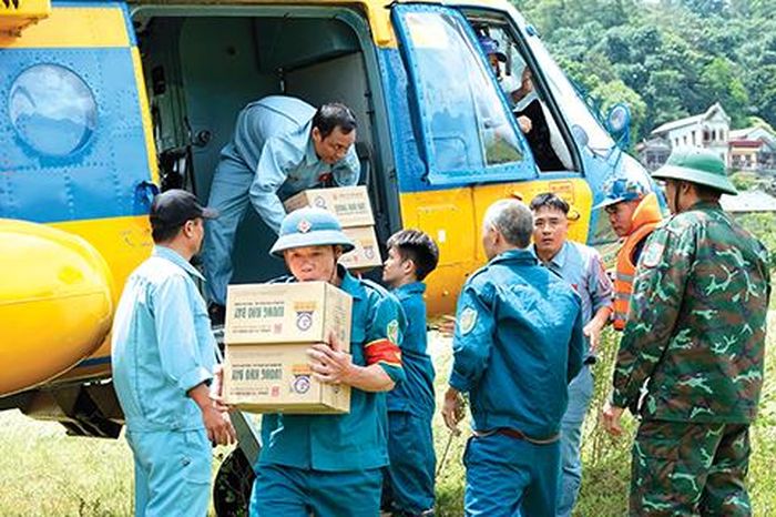 Lực lượng tiếp nhận của huyện Nguyên Bình, tỉnh Cao Bằng vận chuyển nhu yếu phẩm cứu trợ sau khi máy bay hạ cánh. ẢNH: NGUYỄN MINH