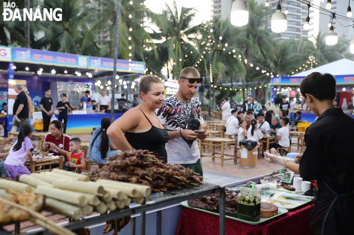 Du khách nước ngoài thích thú trải nghiệm ẩm thực địa phương. Ảnh: NGỌC HÀ
