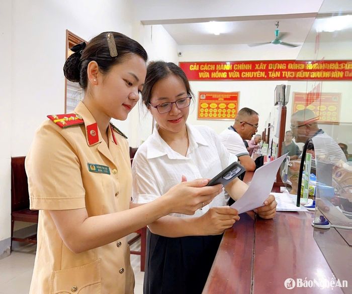 Cán bộ Phòng Cảnh sát giao thông Công an tỉnh hướng dẫn người dân làm thủ tục sang tên xe. Ảnh: P.V