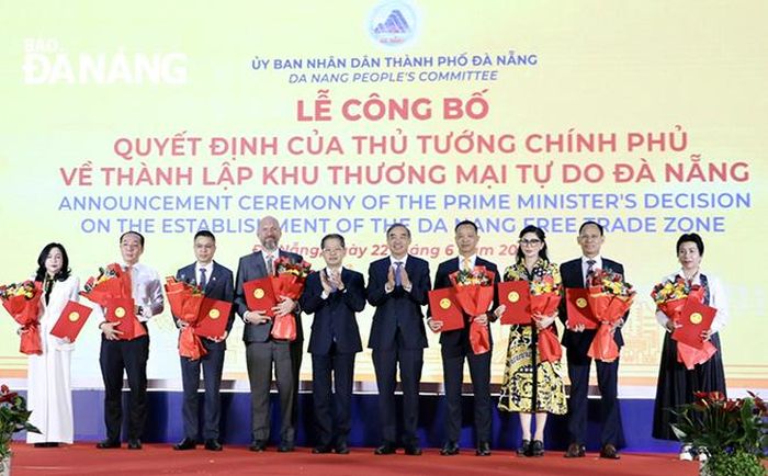 Lãnh đạo thành phố (giữa) trao biên bản ghi nhớ hợp tác giữa UBND thành phố với các nhà đầu tư về phát triển Khu thương mại tự do Đà Nẵng. Ảnh: M.QUẾ