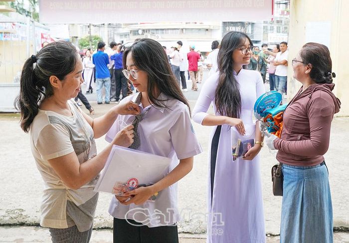 Không chỉ lực lượng “Tiếp sức mùa thi” mà phụ huynh cũng đồng hành cùng con. (Trong ảnh: Phụ huynh em Lâm Huỳnh Anh Thy (bên trái) và em Trương Diễm Quỳnh dặn dò các em trước khi bước vào thi môn văn đầu tiên Kỳ thi Tốt nghiệp THPT năm 2025). Ảnh: HUỲNH LÂM