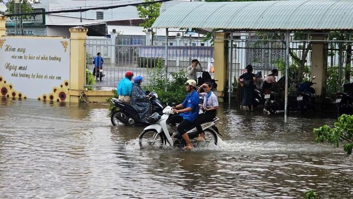  Thanh niên tình nguyện, tại điểm thi Trường THPT Mỹ Xuyên (Sóc Trăng), dùng xe gắn máy chở thí sinh từ cổng trường vào phòng thi an toàn. 