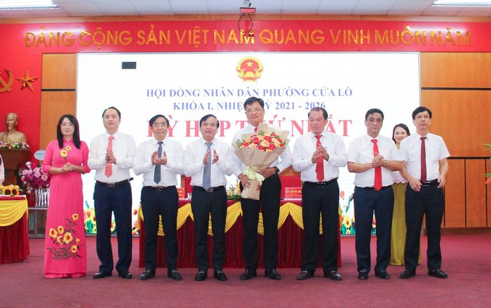 Đồng chí Nguyễn Như Khôi - Ủy viên Ban Chấp hành Đảng bộ tỉnh, Phó Chủ tịch HĐND tỉnh tặng hoa chúc mừng các đồng chí Thường trực HĐND và lãnh đạo UBND phường Cửa Lò. Ảnh: Mai Hoa