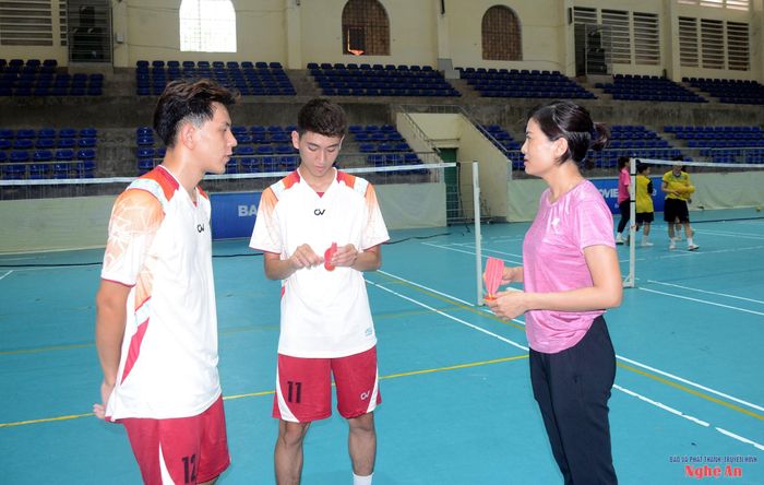 Hai vận động viên Lê Sỹ Khánh (ngoài cùng bên trái) và Lê Anh Đức được huấn luyện viên hướng dẫn chiến thuật thi đấu. Ảnh: Thành Chung