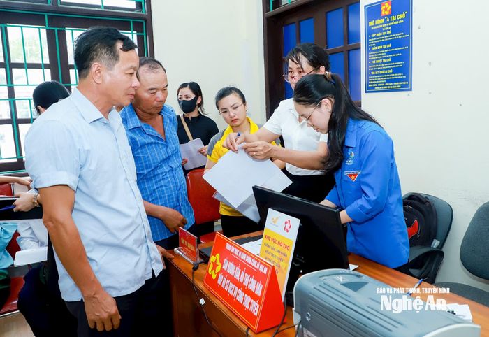 Cán bộ xã Vạn An và thanh niên tình nguyện hướng dẫn công dân thực hiện thủ tục hành chính tại Trung tâm Phục vụ hành chính công xã. Ảnh: Thành Duy