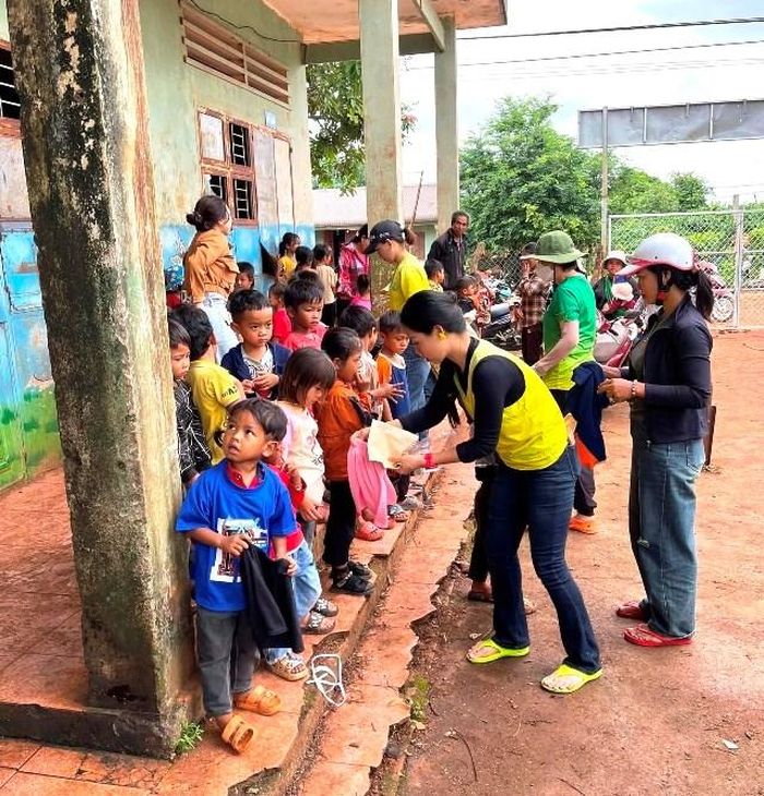 Các thành viên trong CLB Marathon Gia Lai trao tặng quần áo mới cho các em nhỏ tại làng Tào Roòng