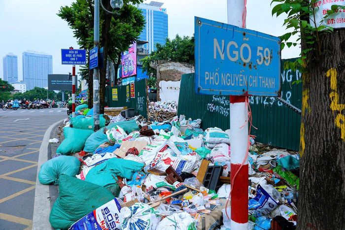 Rác thải được chất thành đống ngay trên vỉa hè đường vành đai 1 tại nút giao Nguyễn Chí Thanh.