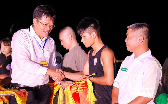 Đồng chí Ngô Đức Kiên - Bí thư phường Cửa Lò tặng cờ lưu niệm cho các đoàn tham gia. Ảnh: Đức Anh
