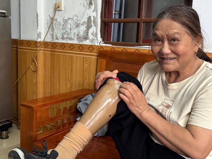  Bà Cảm “khoe” cái chân gỗ - hậu quả của việc dẫm phải mìn khi tham gia xây dựng công trình thủy lợi Nam Thạch Hãn. 