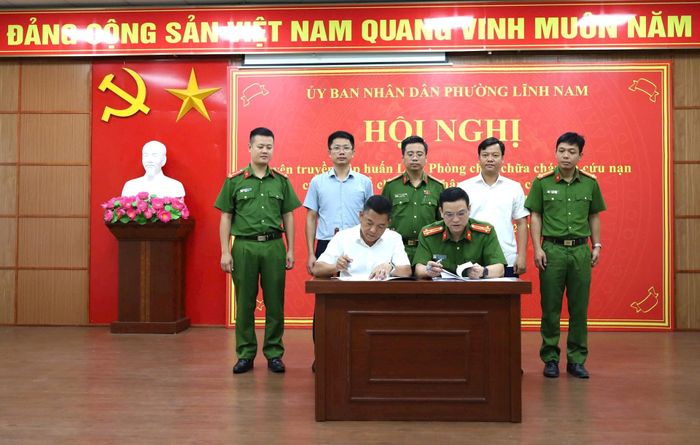 Đại diện lãnh đạo UBND phường Lĩnh Nam và Phòng PC07 ký kết biên bản tiếp nhận, bàn giao danh sách cơ sở theo phân cấp. Ảnh: Hoa Thành