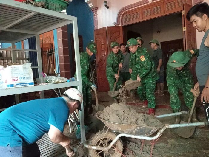 Cán bộ, chiến sĩ Đồn Biên phòng Cửa khẩu Quốc tế Nậm Cắn (Nghệ An) giúp dân khắc phục hậu quả mưa lũ.
