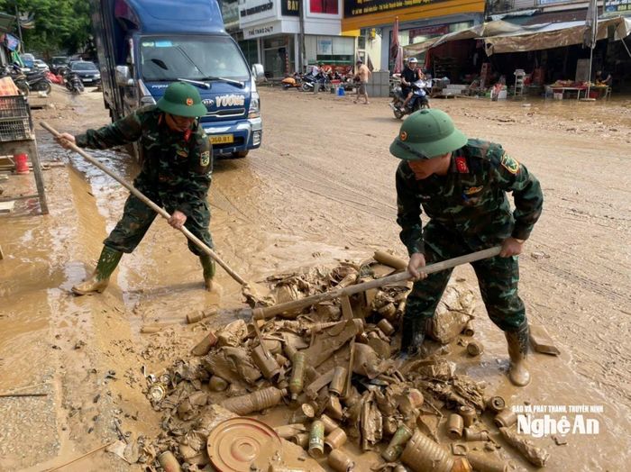 Bộ đội giúp tiểu thương thu dọn, xử lý hàng hàng hóa hư hỏng, làm vệ sinh khu vực chợ Hòa Bình. Ảnh: Đình Tuân