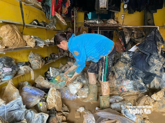 Bà Nguyễn Thị Hường, tiểu thương tại chợ Hòa Bình phân loại hàng hóa bị hư hỏng. Ảnh: Đình Tuân