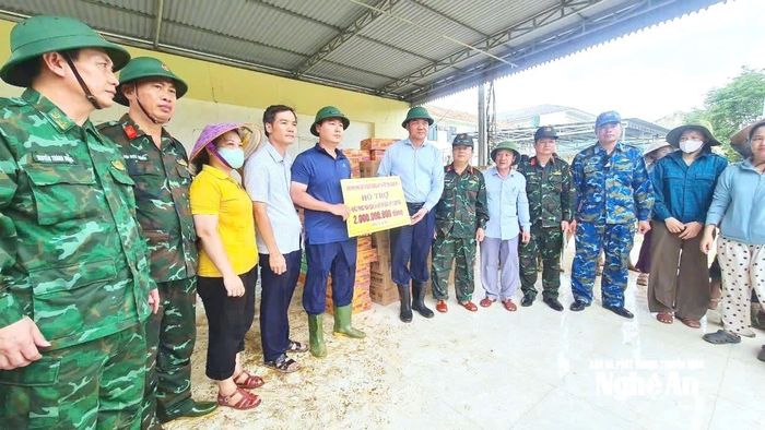Đồng chí Hoàng Nghĩa Hiếu - Phó Bí thư Thường trực Tỉnh ủy, Chủ tịch HĐND tỉnh động viên và trao tiền hỗ trợ cho lãnh đạo cấp ủy, chính quyền xã Tương Dương. Ảnh: Thành Trung
