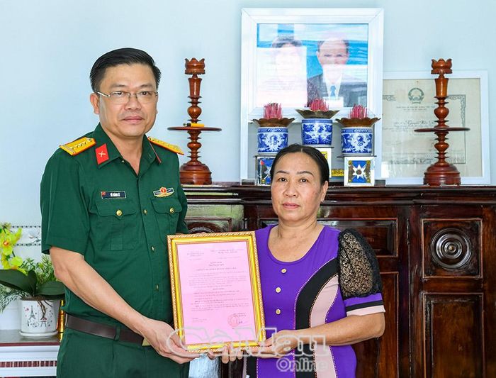 Đại tá Võ Thành Lê, Chính ủy Bộ CHQS tỉnh, trao quyết định nhà tình nghĩa cho gia đình bà Nguyễn Yến Nhi.