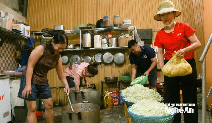 Từ sáng sớm, căn bếp nhỏ tại nhà anh Trần Văn Duy ở khối Hòa Nam, xã Tương Dương đã đỏ lửa. Trong không khí khẩn trương, anh cùng hơn chục người dân trong xóm đang tất bật nấu cơm, kho thịt, xào rau để kịp phát miễn phí cho bà con vùng lũ. Ảnh: Đình Tuân