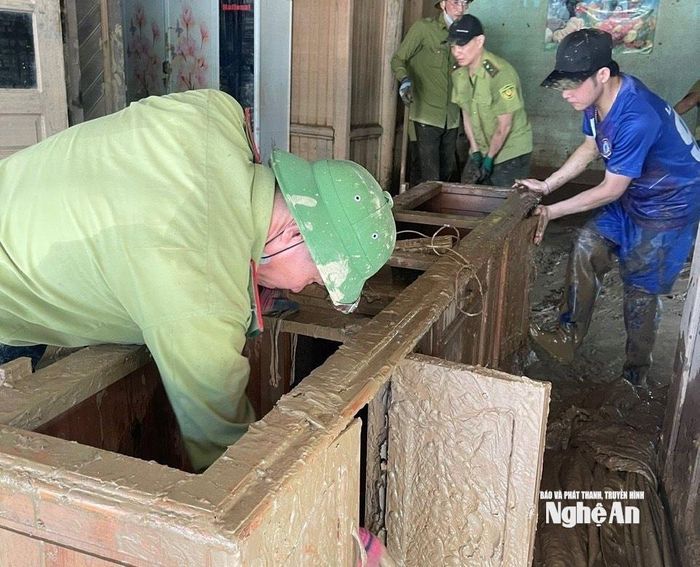 Giúp người dân khắc phục hậu quả lũ lụt, sửa chữa đồ đạc bị hư hỏng tại xã Tương Dương. Ảnh: PV