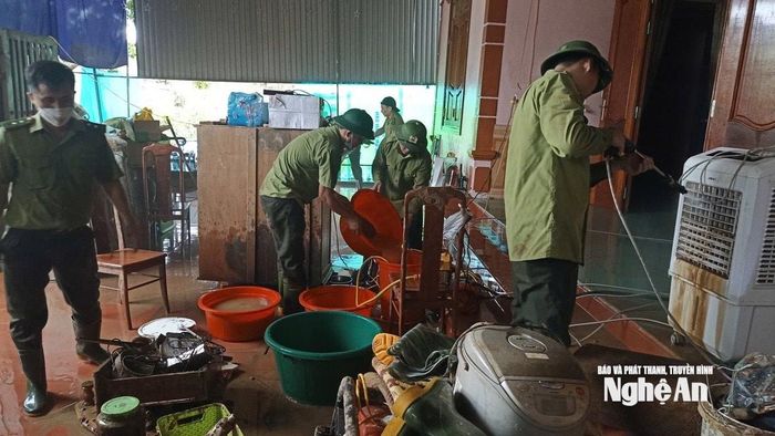 Sử dụng máy bơm nước để phụt rửa đồ đạc cho các hộ dân ở xã Tương Dương sau lũ. Ảnh: PV