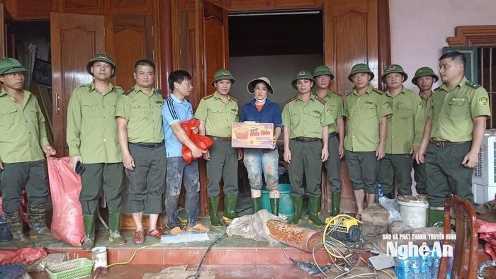 Lãnh đạo Chi cục Kiểm lâm trao quà hỗ trợ cho một hộ dân bị ảnh hưởng bởi lũ tại xã Tương Dương. Ảnh: PV