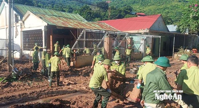 Các cán bộ kiểm lâm không quản ngại vất vả, trực tiếp chung tay giúp người dân xã Mỹ Lý thu dọn đồ đạc bị bùn đất vùi lấp sau trận lũ. Ảnh: PV
