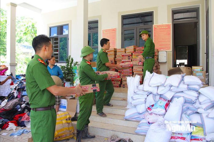 Lực lượng Công an xã Nhôn Mai tiếp nhận và phân phối hàng cứu trợ. Ảnh: Ngân Hạnh