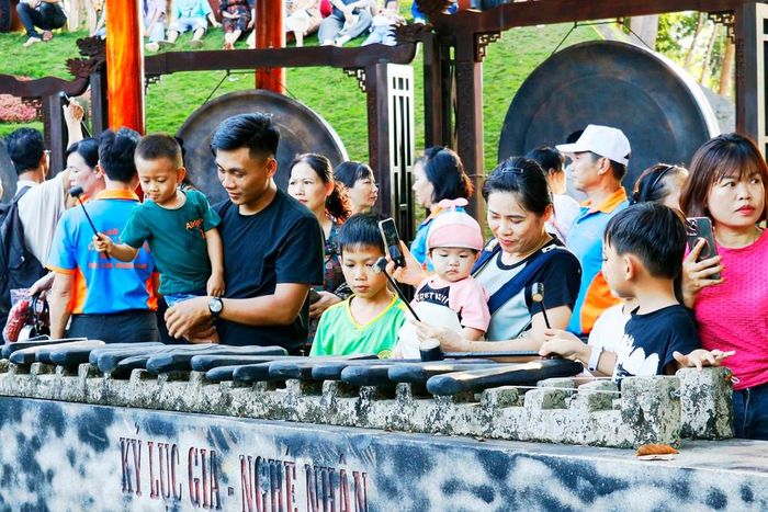 Khách du lịch trải nghiệm đánh đàn đá tại Khu Bảo tồn Văn hóa dân tộc S’tiêng sóc Bom Bo (xã Bom Bo, tỉnh Đồng Nai). Ảnh: Nhật Bình – TTXVN