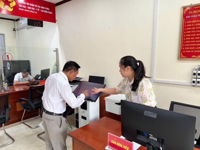 Cán bộ chuyên trách thực hiện chuyển đổi số hỗ trợ người dân thực hiện các thủ tục hành chính trên môi trường điện tử.