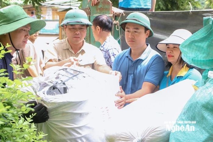 Đồng chí Hồ Lê Ngọc - Ủy viên BTV Tỉnh ủy, Trưởng ban Nội chính Tỉnh ủy và đồng chí Lê Văn Lương, UVBCH Đảng bộ tỉnh, Bí thư Đảng ủy, Chủ tịch HĐND xã Tương Dương và các thành viên nhóm thiện nguyện Niềm Tin trao quà hỗ trợ người dân xã Tương Dương. Ảnh: Phan Hậu