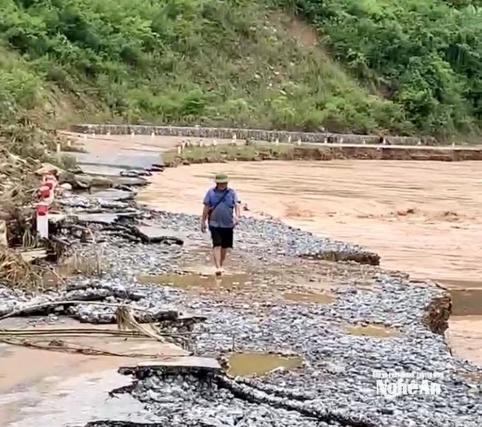 Cán bộ xã Mường Típ men theo vách núi để đi từ Mường Xén vào Mường Típ. Hầu hết đoạn Quốc lộ 7C này đều bị nước lũ cuốn sập xuống sông, chỉ sót lại một vài đoạn song vẫn còn nguy cơ cao cũng sẽ sập. Ảnh: CSCC